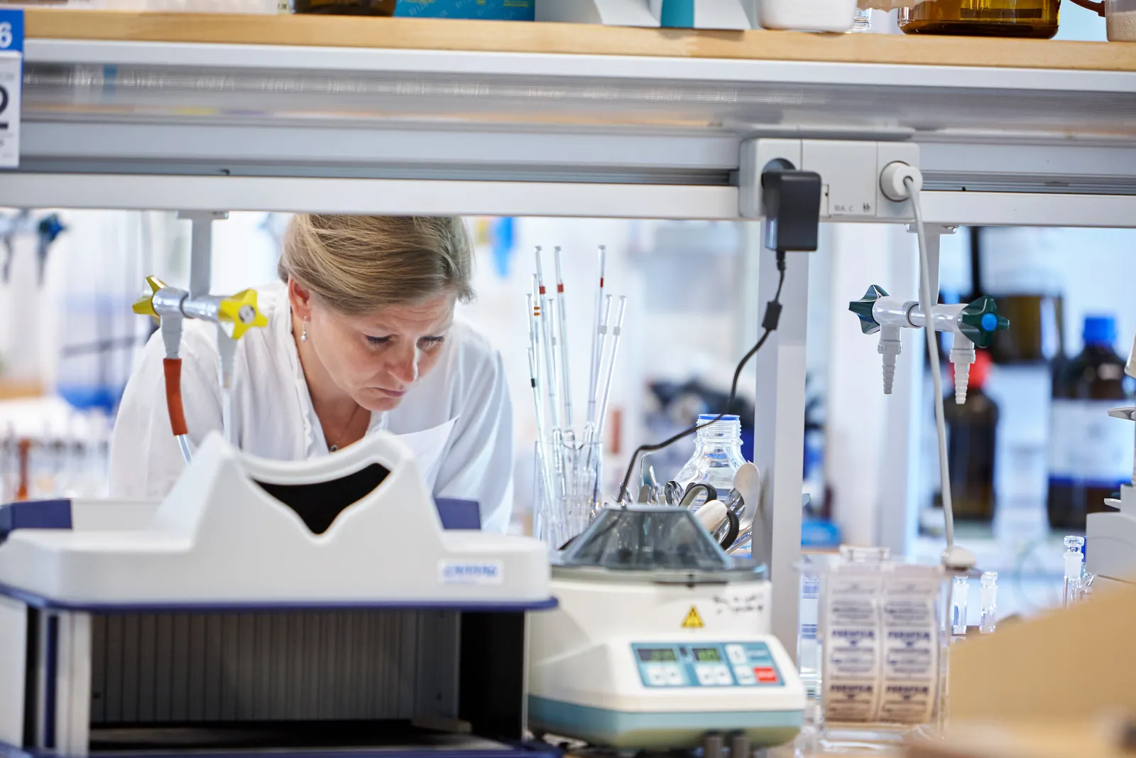 Laborant arbejder bag udstyret i laboratoriet