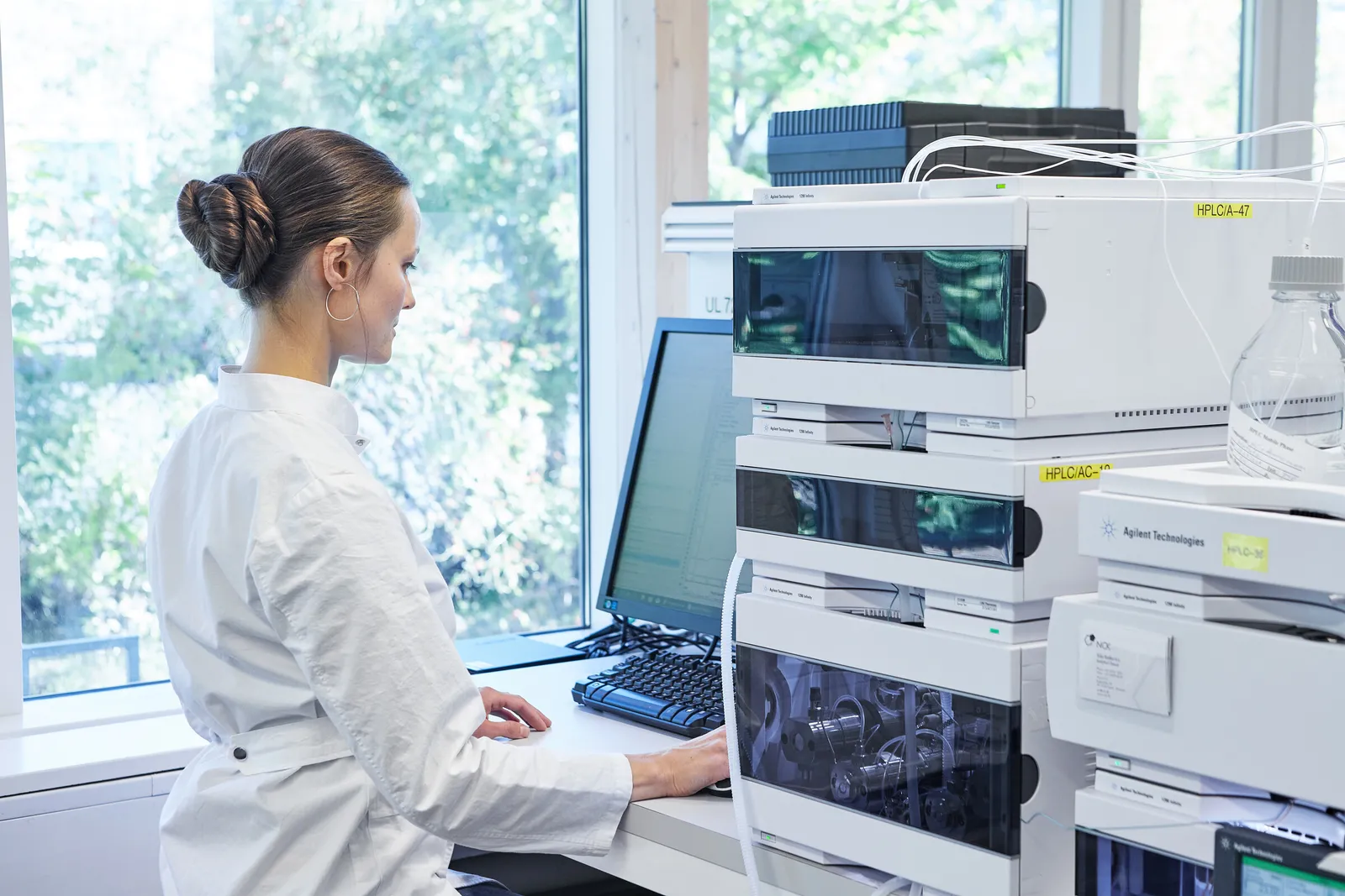 Medarbejder ved computeren mellem analyseinstrumenter