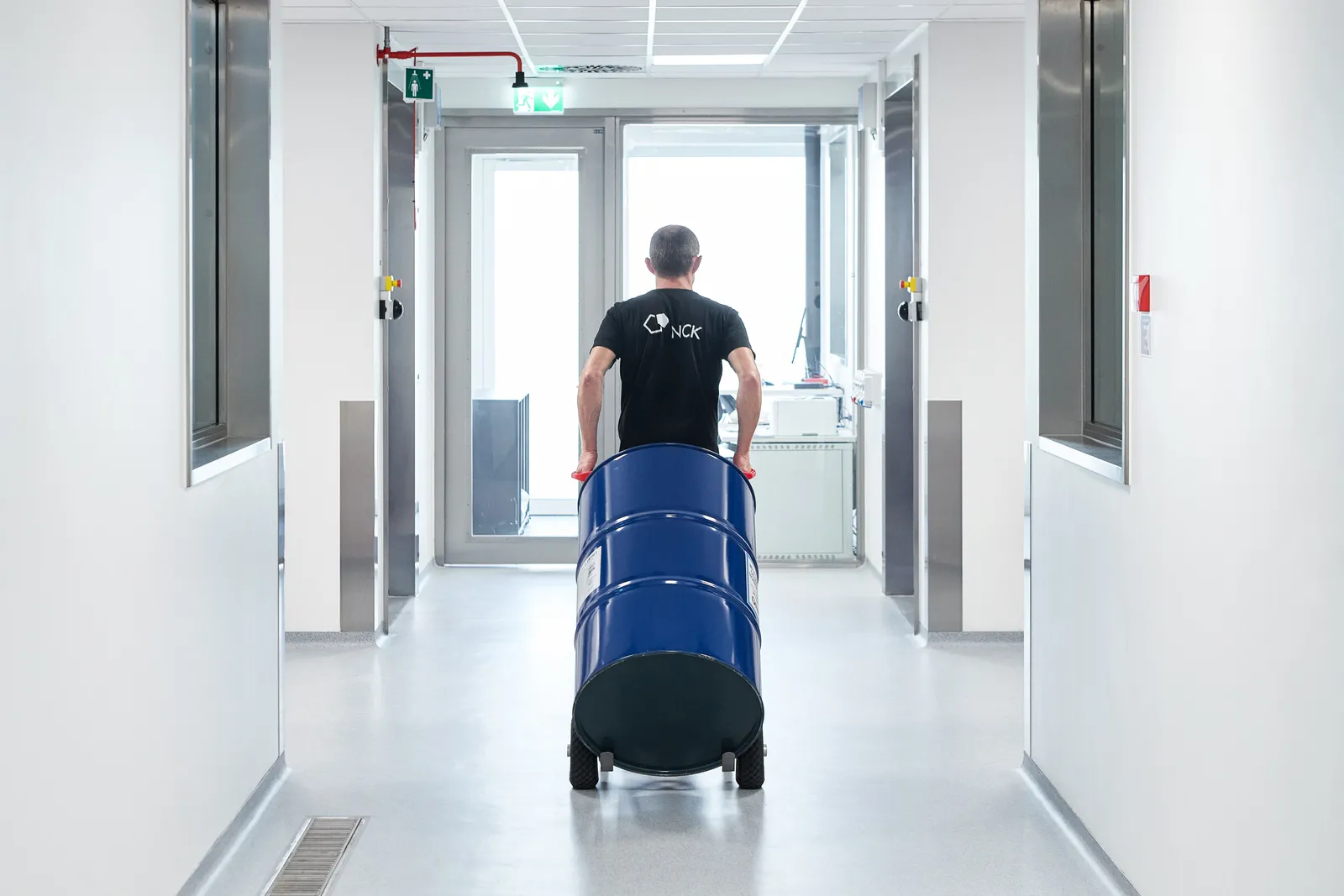 Medarbejder kører den blå tønde videre ad gangen
